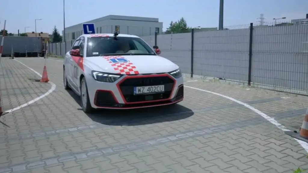Kursantka Gosia w samochodzie na placu manewrowym.
