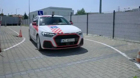 Kursantka Gosia w samochodzie na placu manewrowym.
