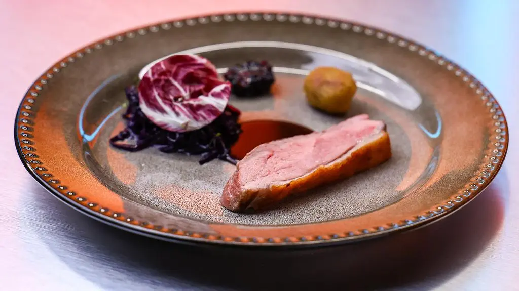 Smażona pierś z kaczki z duszoną czerwoną kapustą, gnocchi z czarnym czosnkiem, marynowaną czerwoną kapustą i sosem z kaczki
