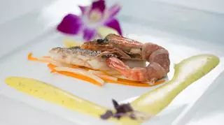 Basia Ritz – Filet z labraksa i krewetki królewskie w szynce parmeńskiej na wiosennych warzywach z tymiankowym sosem zabajone