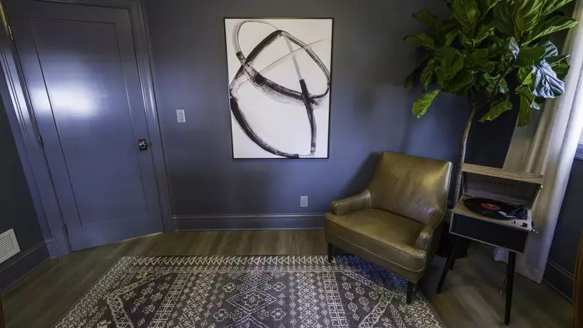 Sztuka nowoczesna na granatowej ścianie i dywan o klasycznym wzorze