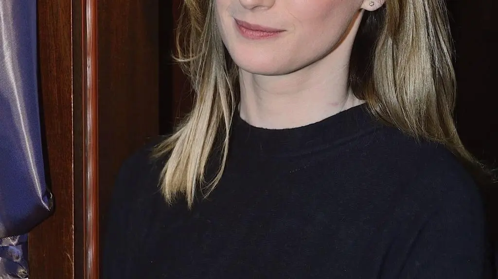 Włosy ciemny blond do ramion, grzywka na bok.