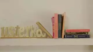 Na półce, którą zamontował fachowiec z "Usterki" leży napis z drewna "Usterka" oraz kilka książek.